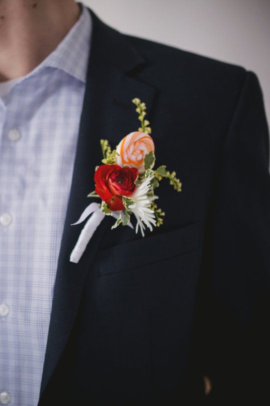 Boutonniere with ranunculus, snowflake mum, solidago and lollipop