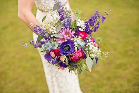Bridal bouquet made with purple anemones, fuchsia ranunculus, blue nigella, purple larkspur, daisies, baby's breath, pink spray roses and seeded eucalyptus | designed by Natasha Price of Alaskaknitnat.com