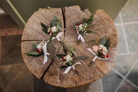 wintertime boutonniere's with blush, white and red | designed by Natasha Price and photo by Grace Adams Photography