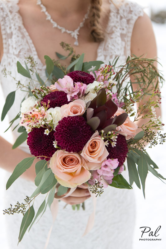 Winter weddings: a bridal bouquet made with peach roses, burgundy chrysanthemums, carnations, alstroemeria, carnations and wax flower. Designed by Natasha Price of Alaskaknitnat.com