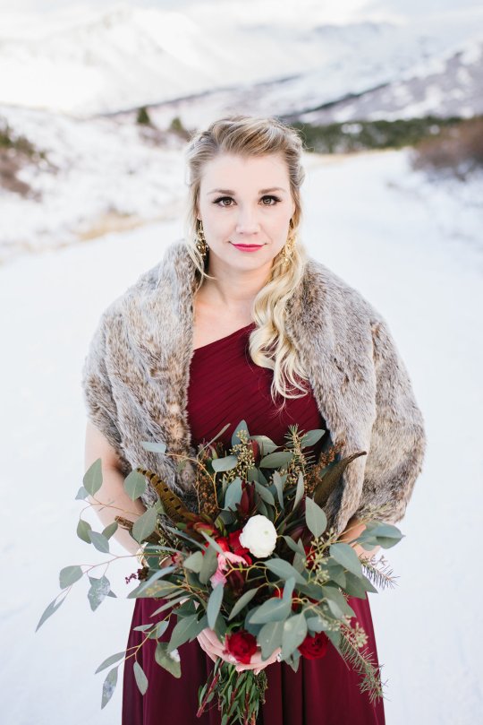 Bridal bouquet made with red and white ranunculus, leucadendron, seeded eucalyptus, spruce boughs and winter foraged greens | a perfect arrangement for a winter wedding.