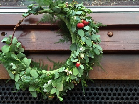 Alaska Winter Wedding: flower crown made with white wax flower, plumosa, eucalyptus, mini myrtle, red hypericum, white statice, and red and white spray roses. It's like a holiday wreath for your head! Designed by Natasha Price of alaskaknitnat.com