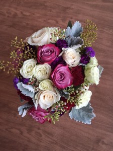 Alaska Winter Wedding | purple roses, plum mini carnations, burgundy carnations, white roses, dusty miller, eucalyptus and wax flower. Bound with white ribbon and a purple corset. Designed by Natasha Price of Alaskaknitnat.com