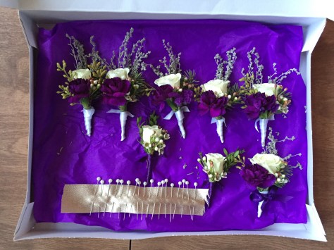 Alaska Winter Wedding | boutonnieres made with white spray roses, statice, sage, waxflower, Sitka spruce, eucalyptus and purple mini carnations. Designed by Natasha Price of Alaskaknitnat.com