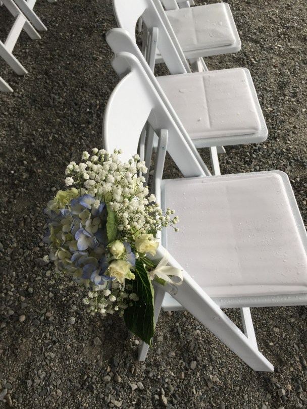 Aisle arrangements made with blue hydrangeas, baby's breath and spray roses | designed by Natasha Price of Alaskaknitnat.com