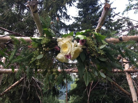 Floral wedding arch arrangements made with garden roses, button mums, hypericum, wax flower, eucalyptus and foraged Alaska greens. |Designed by Natasha Price of Alaskaknitnat.com