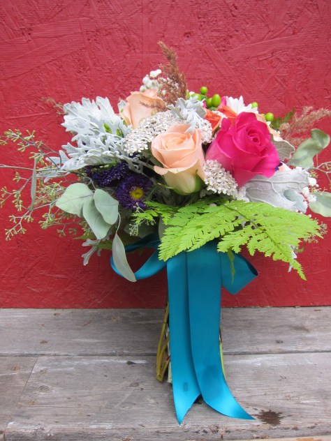 Alaska bridal bouquet with peach and fuchsia roses, purple Japanese aster, green hypericum berry, dusty miller, baby's breath, orange spray roses, seeded eucalyptus and foraged yarrow, grass and ferns. The perfect wild Alaska wedding bouquet. | Designed by Natasha Price of alaskaknitnat.com