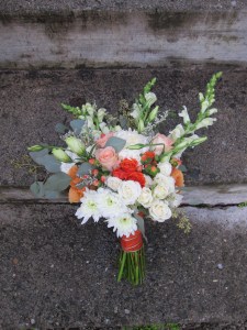 A creamsicle wedding | bridal bouquet made with peach roses, football mums, snapdragon, spray roses, lisianthus, limonium, hypericum and seeded eucalyptus. Designed by Natasha Price of Alaskaknitnat.com