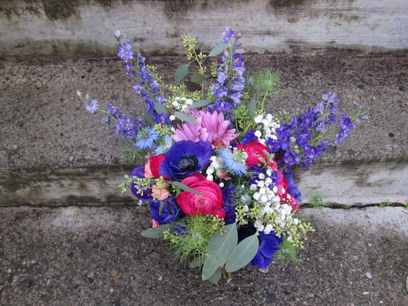 Bridal bouquet made with purple anemones, fuchsia ranunculus, blue nigella, purple larkspur, daisies, baby's breath, pink spray roses and seeded eucalyptus | designed by Natasha Price of Alaskaknitnat.com