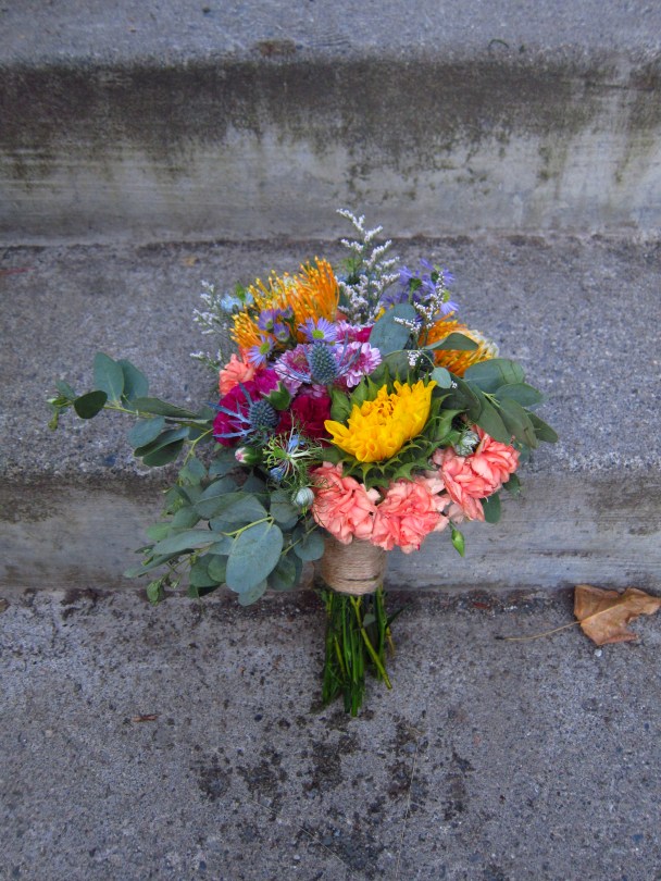 Alaska Weddings: a bridal bouquet made with sunflower, protea, mini carnation, button mums, mini asters, limonium and eucalyptus. Just perfect for a lakeside wedding. Designed by Natasha Price of Alaskaknitnat.com