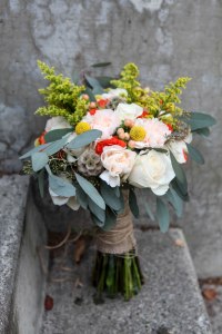 A perfect fall bridal bouquet. Solidago, white roses, orange spray roses, salmon hypericum berry, billy ball, scabiosa pods, peach carnation and seeded eucalyptus wrapped in burlap with jute twine corset | designed by Natasha Price of alaskaknitnat.com