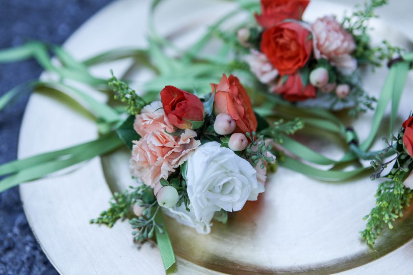 Autumn wrist corsage made with orange spray rose, billy ball, hypericum, solidago and seeded eucalyptus | designed by Natasha Price of alaskaknitnat.com