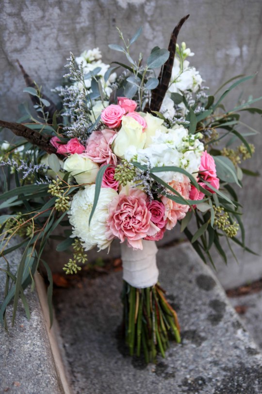 Shabby chic bridal bouquet made with eucalyptus, feathers, carnations, football mums, roses, stock and spray roses | designed by Natasha Price of Alaskaknitnat.com