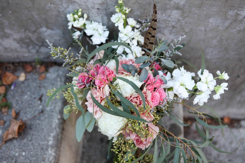 Shabby chic bridal bouquet made with eucalyptus, feathers, carnations, football mums, roses, stock and spray roses | designed by Natasha Price of Alaskaknitnat.com