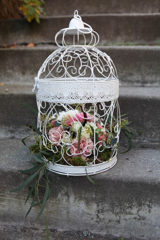 Birdcage flower arrangement for a fairy tale wedding. Made with eucalyptus, carnations, football mums, roses, stock and spray roses | designed by Natasha Price of Alaskaknitnat.com