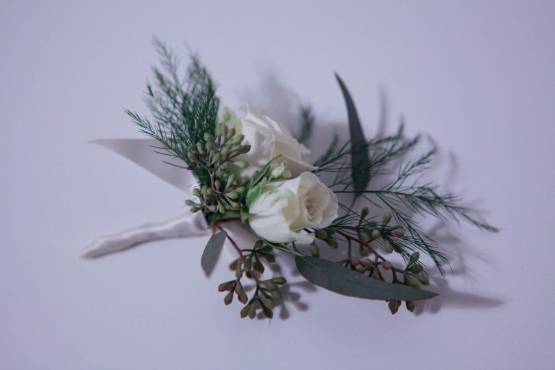 Boutonniere made with white spray rose, seeded eucalyptus and tree fern | designed by Natasha Price of alaskaknitnat.com